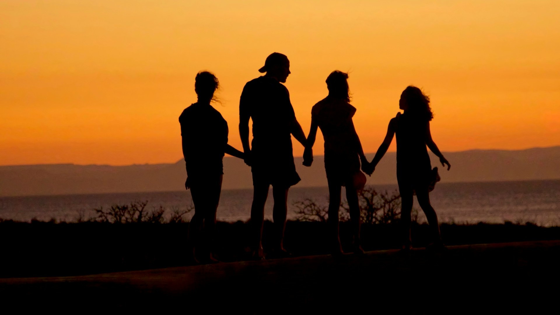 Silhouet van familie hand in hand bij zonsondergang als symbool voor afscheid regelen na een overlijden