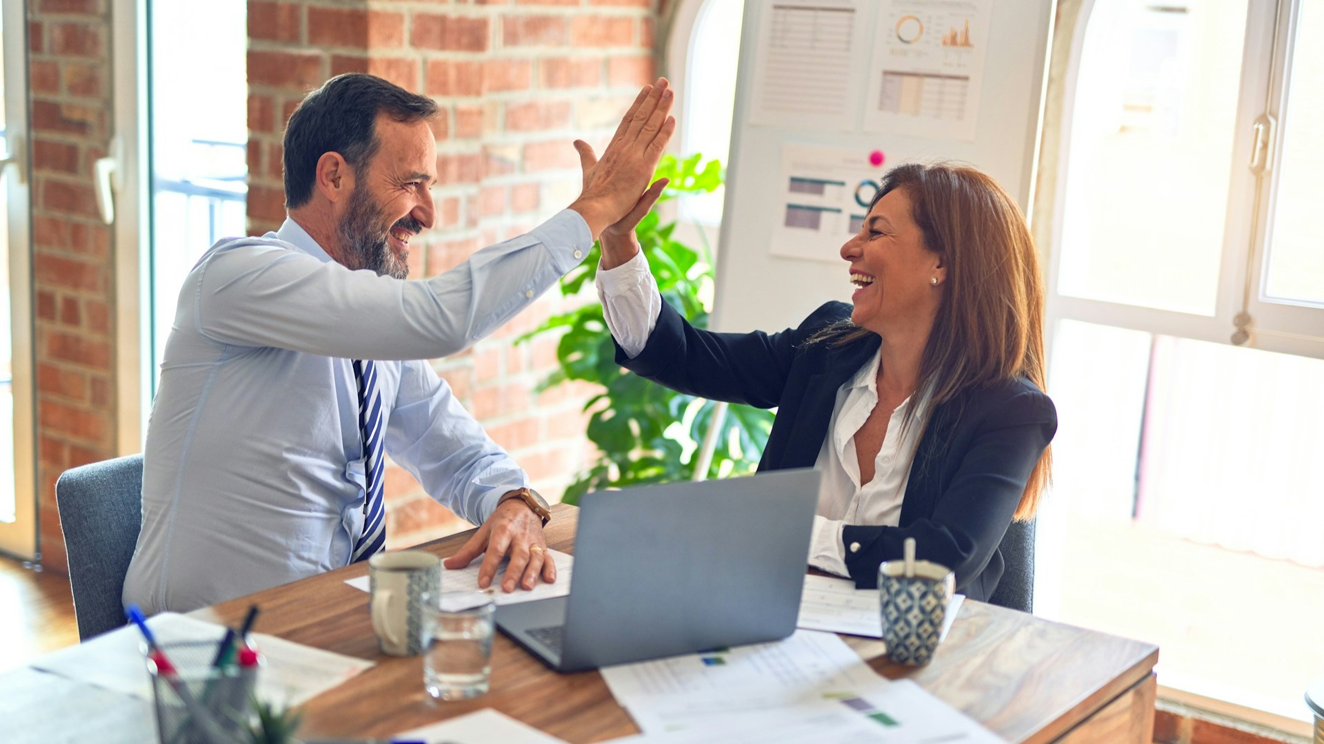 Twee ondernemers geven elkaar een high five na het benutten van zakelijke kansen