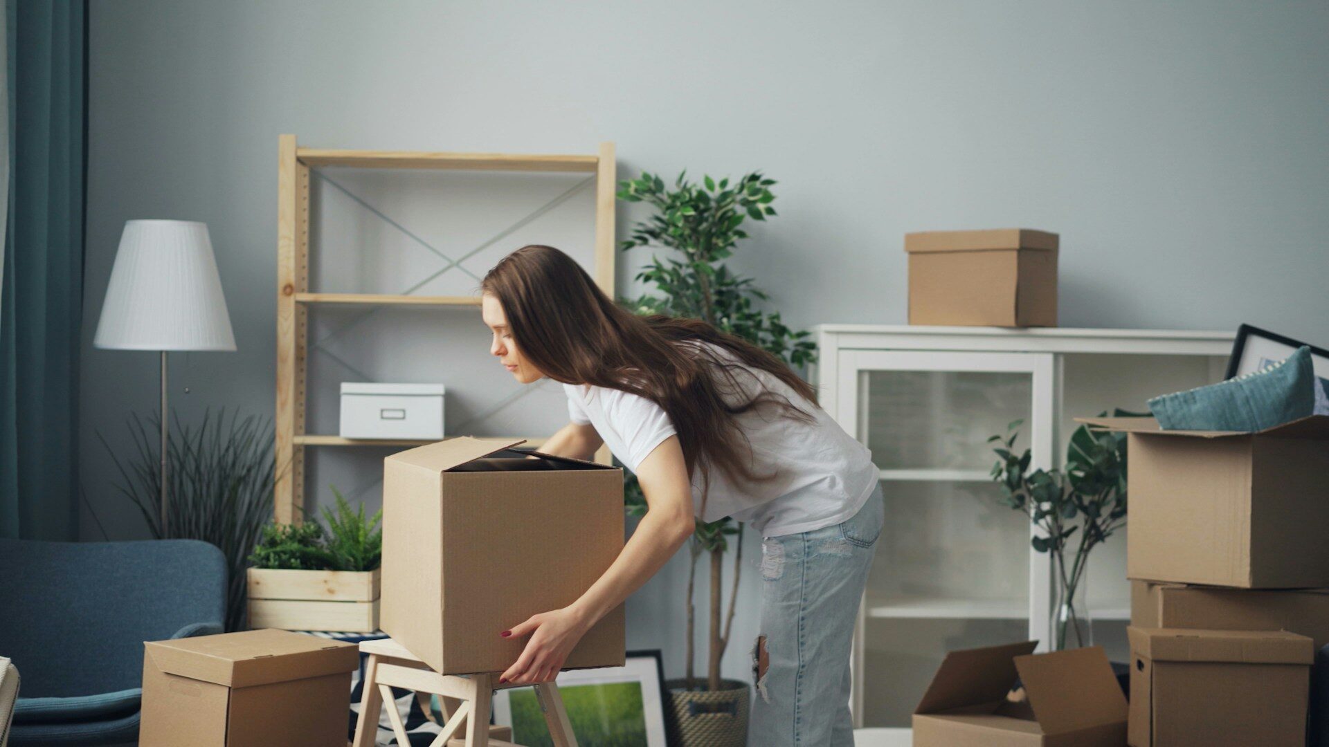 Vervoer bij verhuizing met verhuisdozen en meubels in woonkamer tijdens het inpakken en verplaatsen