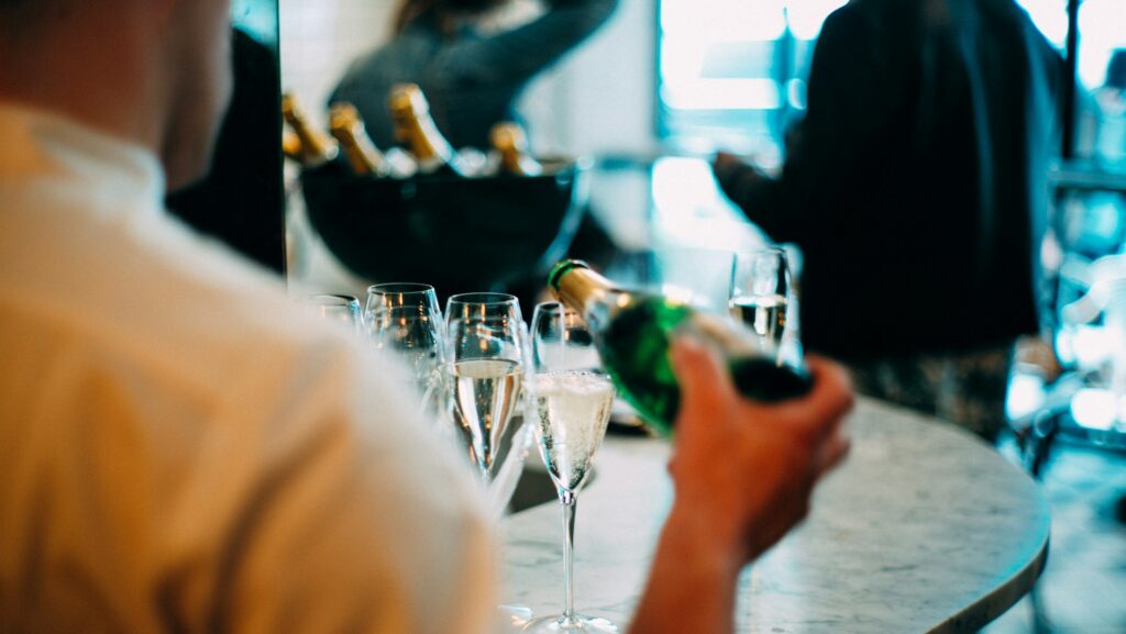 Server schenkt champagne in restaurant tijdens restaurant starten begeleiding proces