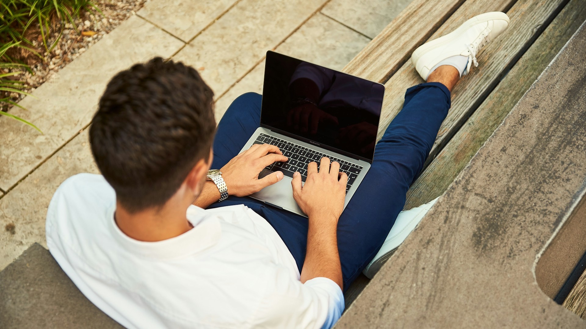 Administratie zzp’er digitaal bijhouden op laptop terwijl iemand buiten werkt aan boekhouding