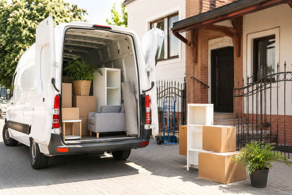 Verhuisbus met verhuisdozen en meubels voor een woning tijdens een particuliere verhuizing.