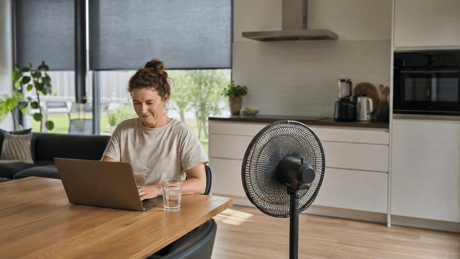 vrouw thuis aan het werk achter laptop met ventilator aan